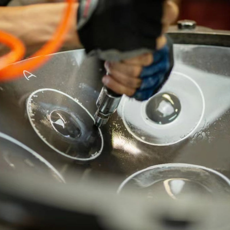 A professional tuner calibrating a handpan for sale to achieve harmonic resonance