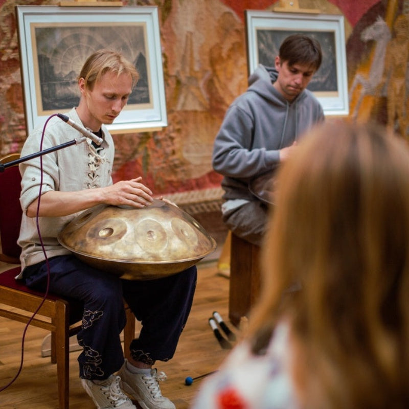 Musicians gathered in an outdoor setting, playing handpans and enjoying a peaceful jam session.