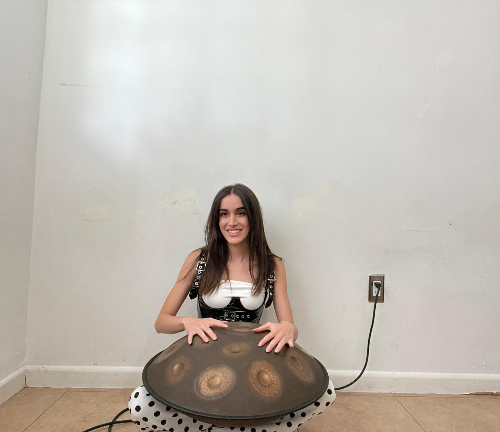 Musician practicing handpan in a cozy indoor setting