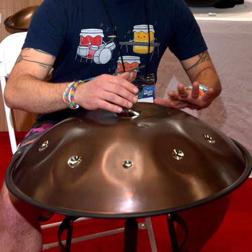 A musician sitting cross-legged in a cozy living room, passionately playing a handpan