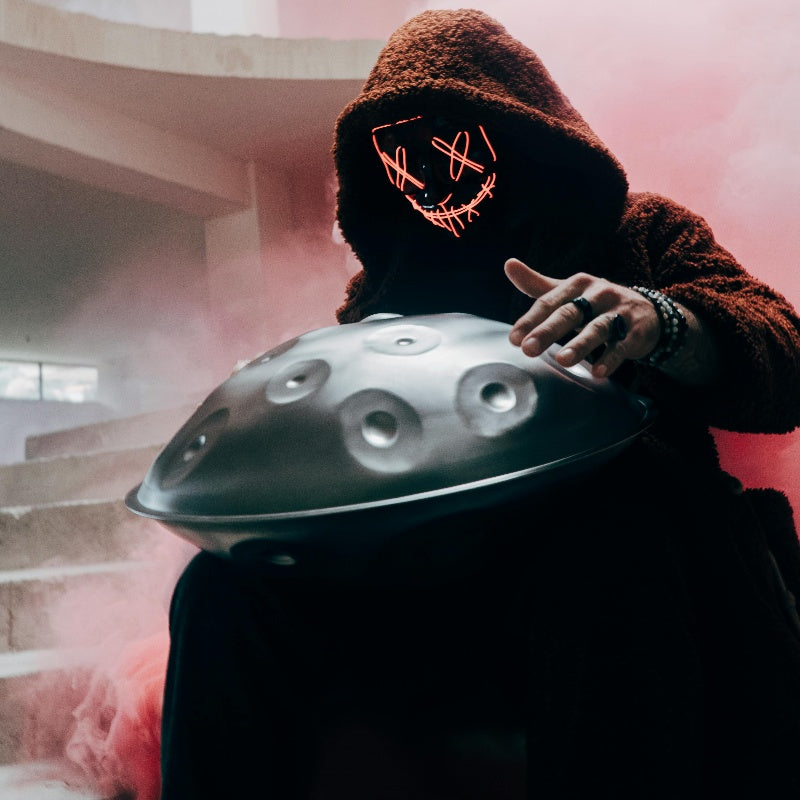 Masked musician creating music with handpan